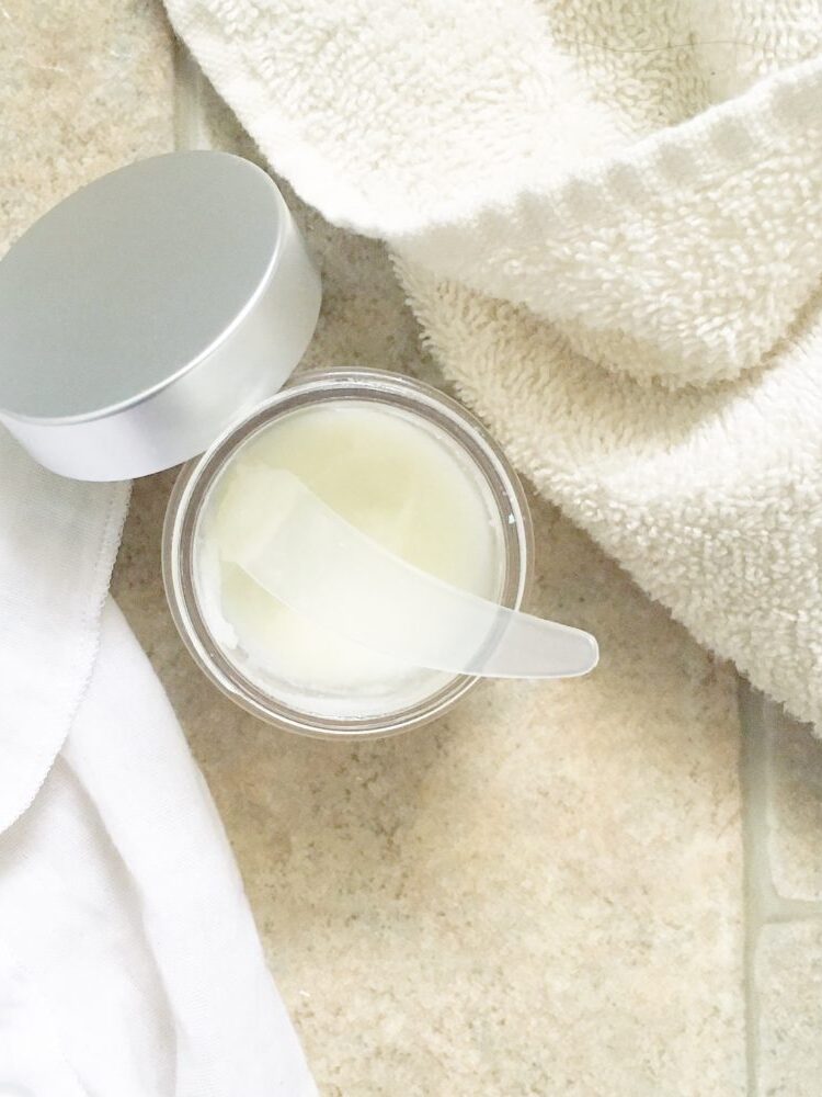 An open jar of beauty cream and towels.