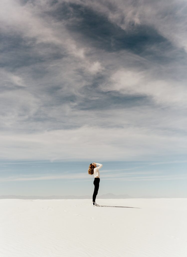 Woman on beach face in hands